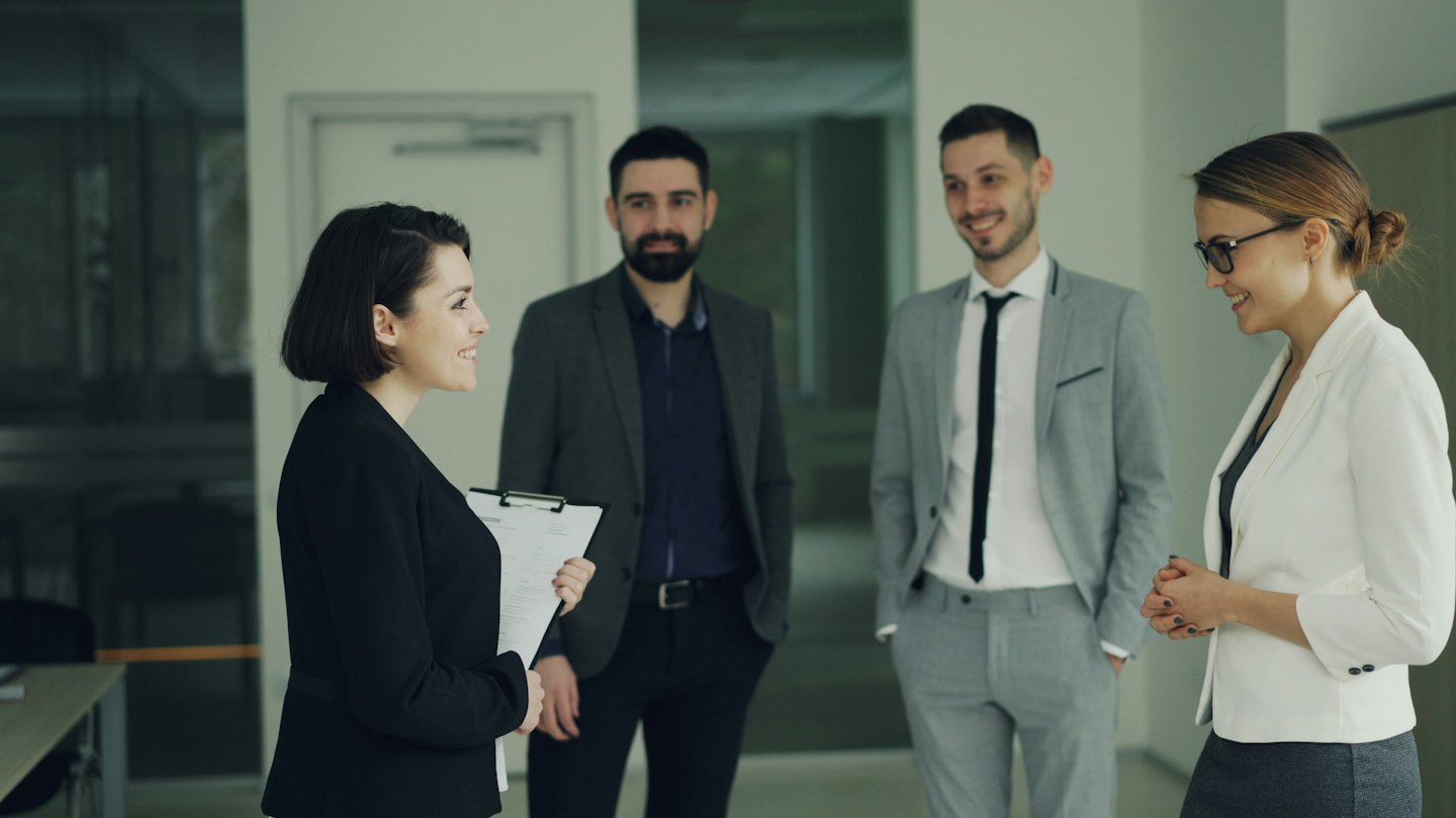 Geschäftsleute besprechen Ideen in einem modernen Büroflur.
